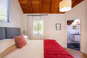a bedroom with a large bed with a red blanket at Taramea Arrowtown by Sotheby's Luxury Rental Homes in Queenstown