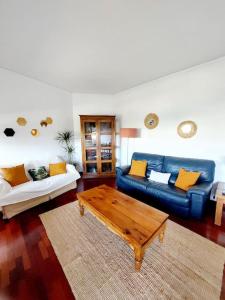a living room with a blue couch and a coffee table at Charming Avenue Apartment in Faro