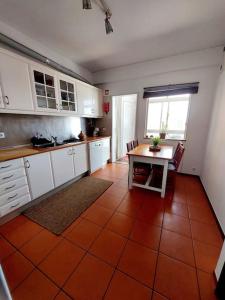 a kitchen with an orange tile floor and a table at Charming Avenue Apartment in Faro