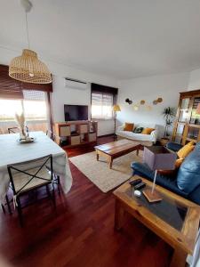 a living room with a blue couch and a table at Charming Avenue Apartment in Faro