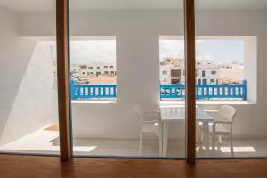 een eetkamer met een tafel en stoelen en een balkon bij Casa Manrique in Famara