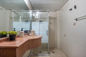 uma casa de banho com um lavatório e um chuveiro em Boutique Suites - Prime Location Old City em Safed