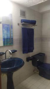 a bathroom with a blue sink and a toilet at *Tulli Apartmentos Margarita Island* in Porlamar