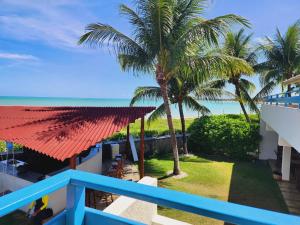 einen Blick vom Balkon eines Resorts mit Palmen in der Unterkunft Manaí Pousada & Beach Club in Barra de Santo Antônio