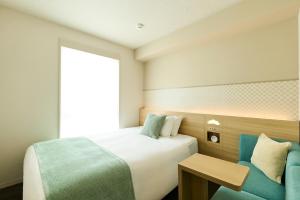 ein Hotelzimmer mit einem Bett und einem Stuhl in der Unterkunft RIHGA Place Kyoto Shijo Karasuma in Kyoto