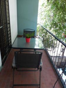 una mesa en un balcón con una planta en Quinta House en Mendoza