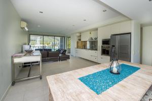 a kitchen and living room with a table and a refrigerator at Blue on Blue Apartment 327 in Nelly Bay