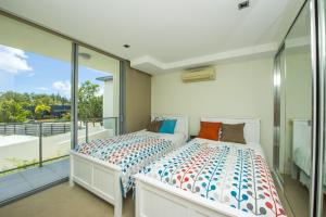 a bedroom with a bed and a balcony at Blue on Blue Apartment 327 in Nelly Bay +11 photos