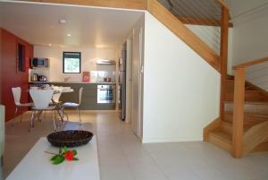 uma cozinha e sala de jantar com uma escada numa casa em Canopy Chalet 4 em Nelly Bay