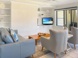a living room with a couch and chairs and a tv at Magnetic Docks Townhouse 9 in Nelly Bay