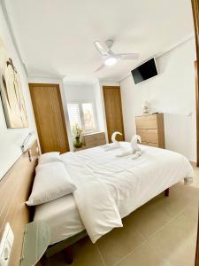 - une chambre avec un grand lit et des draps blancs dans l'établissement Apartamento Pueblo Dorado, à Mojácar