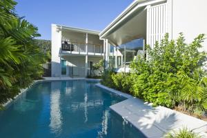 a swimming pool in front of a house at The Boathouse in Nelly Bay