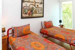 a bedroom with a bed and a couch next to a window at The Boathouse in Nelly Bay +6 photos