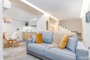 uma sala de estar com um sofá azul com almofadas amarelas em FEEL - Grand Alta Apartment em Bérgamo