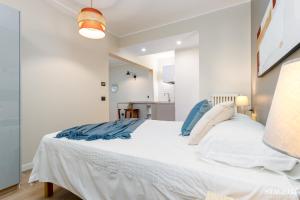 um quarto com uma grande cama branca com almofadas azuis em FEEL - Grand Alta Apartment em Bérgamo