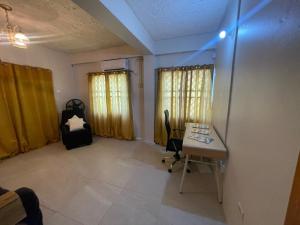 ein Büro mit einem Schreibtisch und einem Stuhl in einem Zimmer in der Unterkunft Mango Vert House in Arima