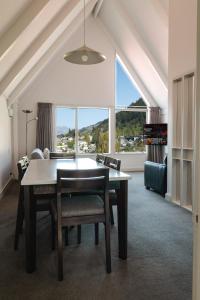 a dining room with a table and chairs and a large window at Turner Heights Townhouses in Queenstown