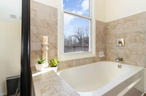 a large white tub in a bathroom with a window at Downtown Views-Prime Location! in Cincinnati +29 photos