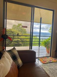 a living room with a view of the ocean through a sliding glass door at Ferreto`s House in El Castillo de La Fortuna