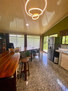 cocina con mesa de madera y nevera en Ferreto`s House, en El Castillo de La Fortuna