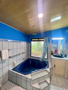 El baño incluye una gran bañera azul. en Ferreto`s House, en El Castillo de La Fortuna
