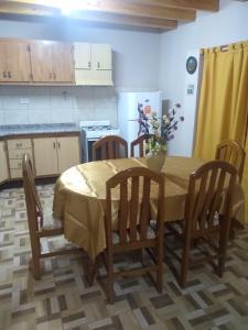 cocina con mesa y sillas y cocina con nevera en Complejo Las Rosas en Luján de Cuyo