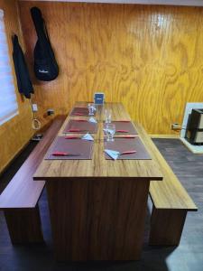 una mesa de madera con copas de vino y servilletas. en Casa en Puerto Natales en Puerto Natales