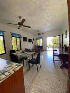 - un salon avec des tables, des chaises et des fenêtres dans l'établissement Ruhig, gross mit herrlicher Aussicht, à San Felipe de Puerto Plata