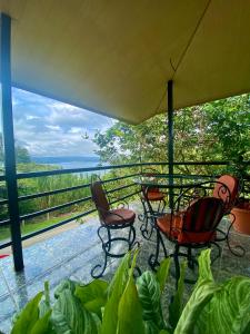 um alpendre com cadeiras e vista para a água em Ferreto`s House em El Castillo de La Fortuna