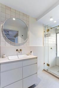 ein weißes Badezimmer mit Waschbecken und Spiegel in der Unterkunft Village vibes & coastal life, Sunshine Beach in Sunshine Beach + 8 Fotos