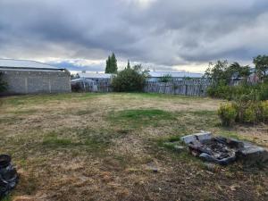 een achtertuin met een vuurplaats in het gras bij Casa en Puerto Natales in Puerto Natales