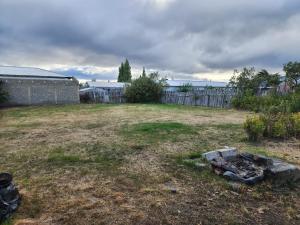 a backyard with a fire pit in the grass at Casa en Puerto Natales in Puerto Natales