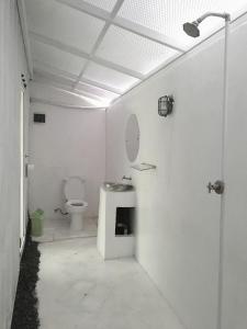 a white bathroom with a toilet and a sink at Kubu Container in Uluwatu