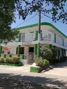 a building with a green and white at Sol y Mar in Puerto Limón
