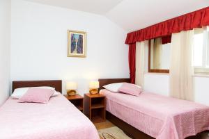 1 dormitorio con 2 camas y ventana en Apartments Lepur, en Dubrovnik