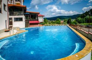 una gran piscina de agua azul frente a una casa en Апартамент Lake, en Tryavna