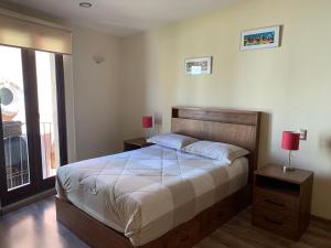 1 dormitorio con 1 cama con 2 lámparas y una ventana en Loft Bonanza Premier en Valquirico, en Tlaxcala de Xicohténcatl