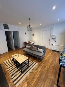 ein Wohnzimmer mit einem Sofa und einem Tisch in der Unterkunft Le voltaire 1 chez Adrien in Saint-Quentin