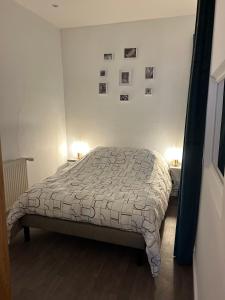ein Schlafzimmer mit einem Bett, zwei Tischen und zwei Lampen in der Unterkunft Le voltaire 1 chez Adrien in Saint-Quentin