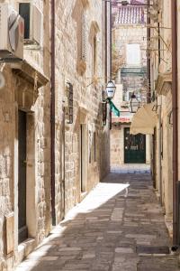 an alleyway in an old town with stone buildings at Apartments Lepur in Dubrovnik