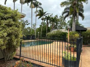 a black fence in front of a swimming pool at Mareeba Motor Inn in Mareeba