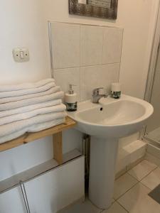 uma casa de banho com lavatório, espelho e toalhas em Le Voltaire 4 chez Adrien Hyper centre em Saint-Quentin
