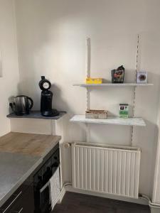 uma cozinha com prateleiras brancas e um radiador em Le Voltaire 4 chez Adrien Hyper centre em Saint-Quentin