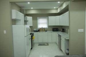 uma cozinha com armários brancos e um frigorífico branco em Z & Z APARTMENT 3 em Newark