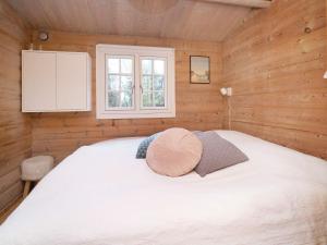 a bedroom with a white bed in a wooden cabin at 7 person holiday home in Højby-By Traum in Højby