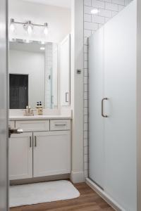 ein weißes Badezimmer mit einem Waschbecken und einem Spiegel in der Unterkunft Capri 315 the Heart of Old Town Traverse City in Traverse City