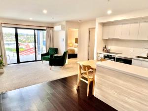 eine Küche und ein Wohnzimmer mit einem Tisch und Stühlen in der Unterkunft Sixty Six Boutique Apartments in Hobart