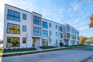 an exterior view of a white building with windows at Cypress Penthouse Traverse City Condo in Traverse City