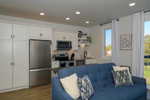 a living room with a blue couch and a kitchen at Cypress Penthouse Traverse City Condo in Traverse City