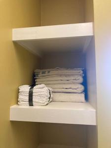 a group of towels on a shelf in a bathroom at Green Home 25 min from downtown in Nashville